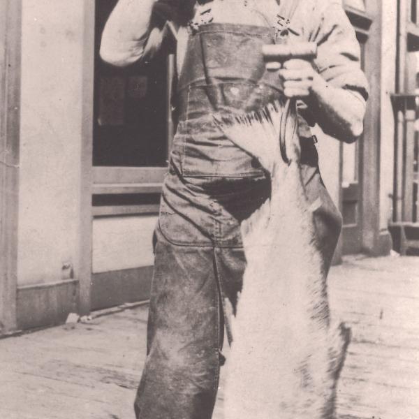 Sephardic immigrant Nessim Chiprut holds a large fish, probably at Pike Place Market. (1920s)
