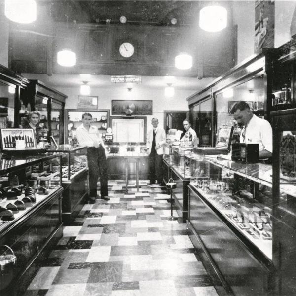Ben Bridge Jeweler interior in 1939. Herb's mother Sally Bridge is on the far left, Leo Bridge, far left, leaning; watchmaker Phil Blanks; Ben Bridge's cousin Max Flaks; and another watchmaker, Otis Cook, near right.