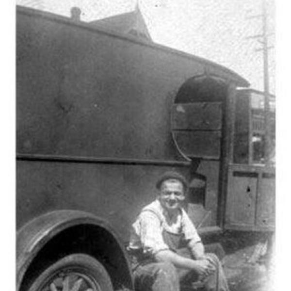 Itsey Brenner sitting on the runner of a Brenner Brothers Bakery delivery truck ca 1920s