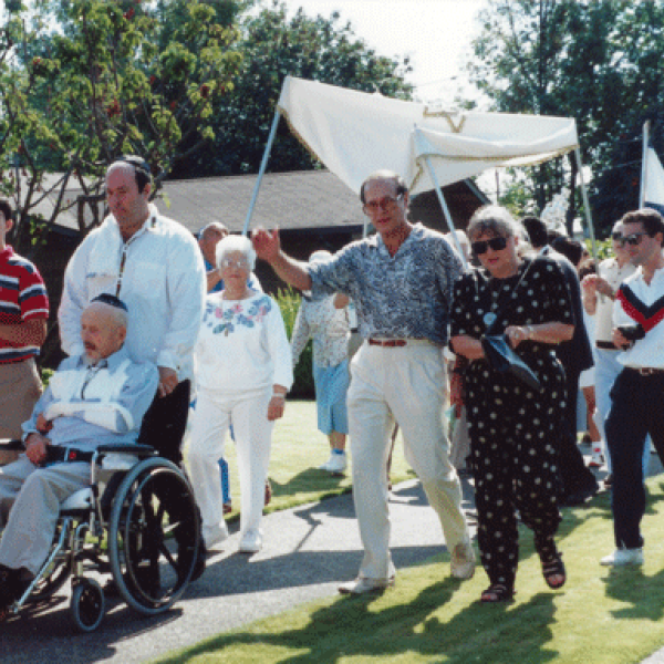 Sefer Torah parade, from Kline Galland Home to Congregation Ezra Bessaroth, August 17, 1991. Left to right: Eddie Hasson, Randy Hasson, Michael Toobert pushing Sam in wheelchair, Bona Hasson, Morrie Capaluto, Jewel Capaluto, Norman Behar, Jerry Cohen.  Photo courtesy Samis Foundation