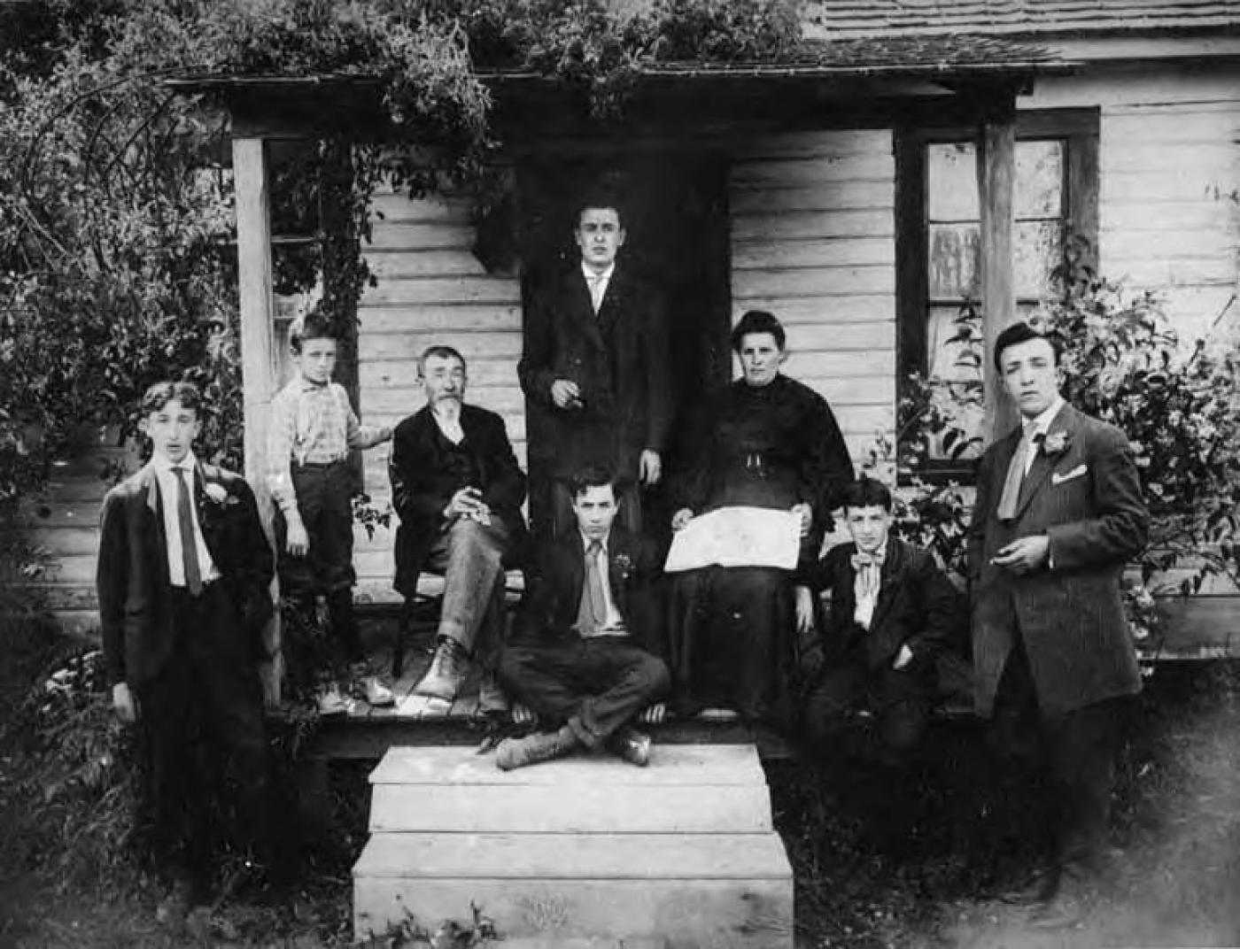 Shain family sitting on porch at Home Colony farmhouse, approximately 1918