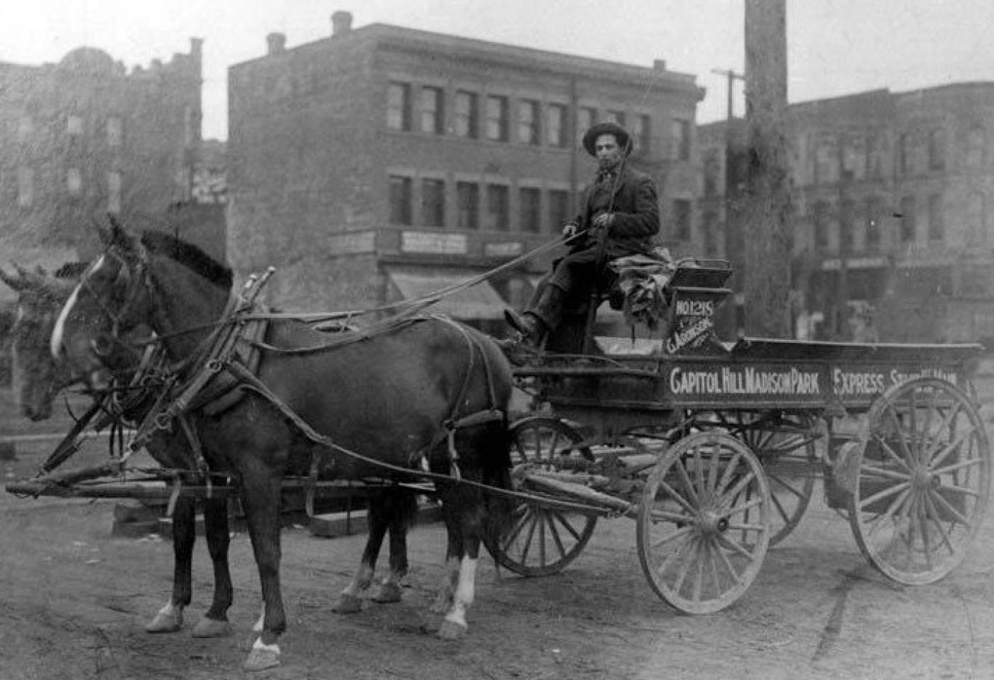 Charles Aronson sitting in horse-drawn delivery wagon outside his hardware business at 111 1st Ave. S., Seattle, approximately 1905-1910