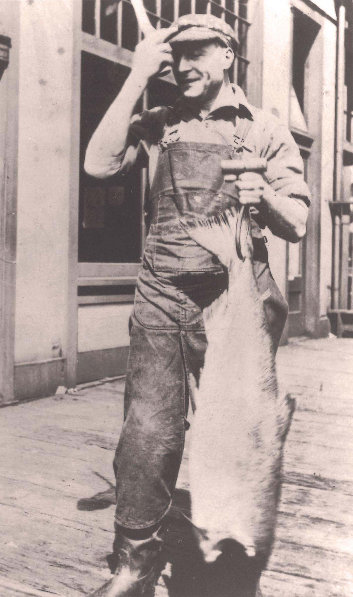 Sephardic immigrant Nessim Chiprut holds a large fish, probably at Pike Place Market. (1920s)