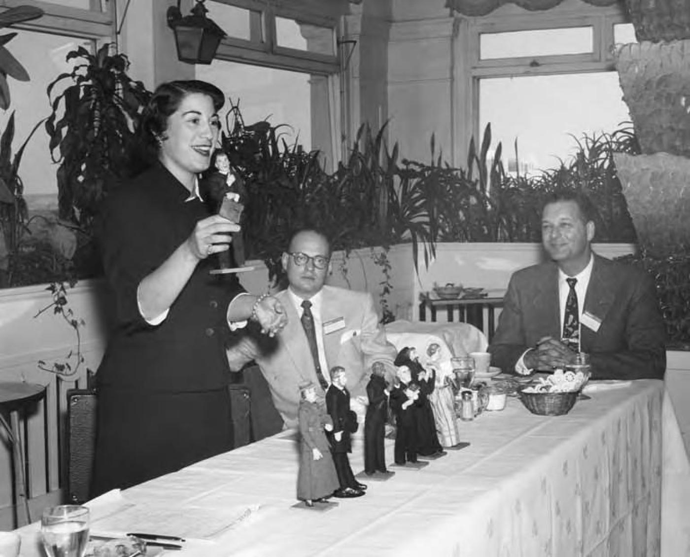 Seymour Kaplan sitting at table with man and woman at 1st Annual Meeting of Plains States, October 11, 1953