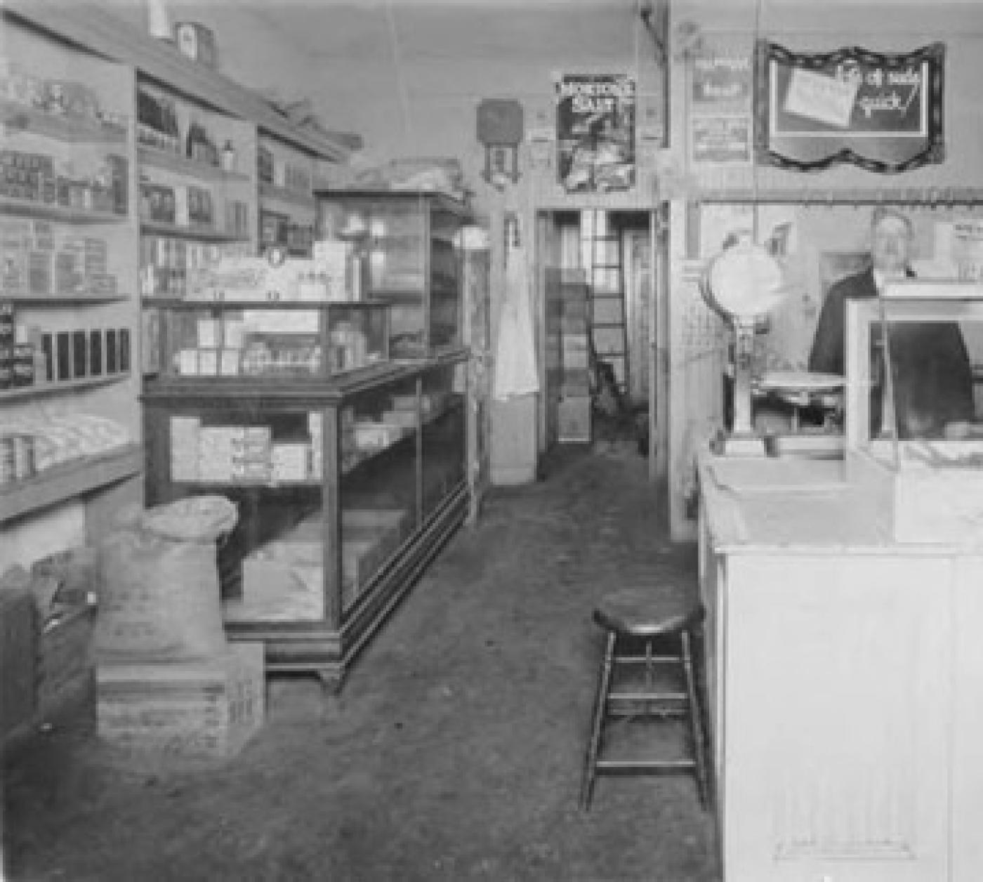 Interior of Kutoff Butcher Shop on Yesler Way between 19th and 20th Avenues with Marcus Kutoff standing behind counter, 1931