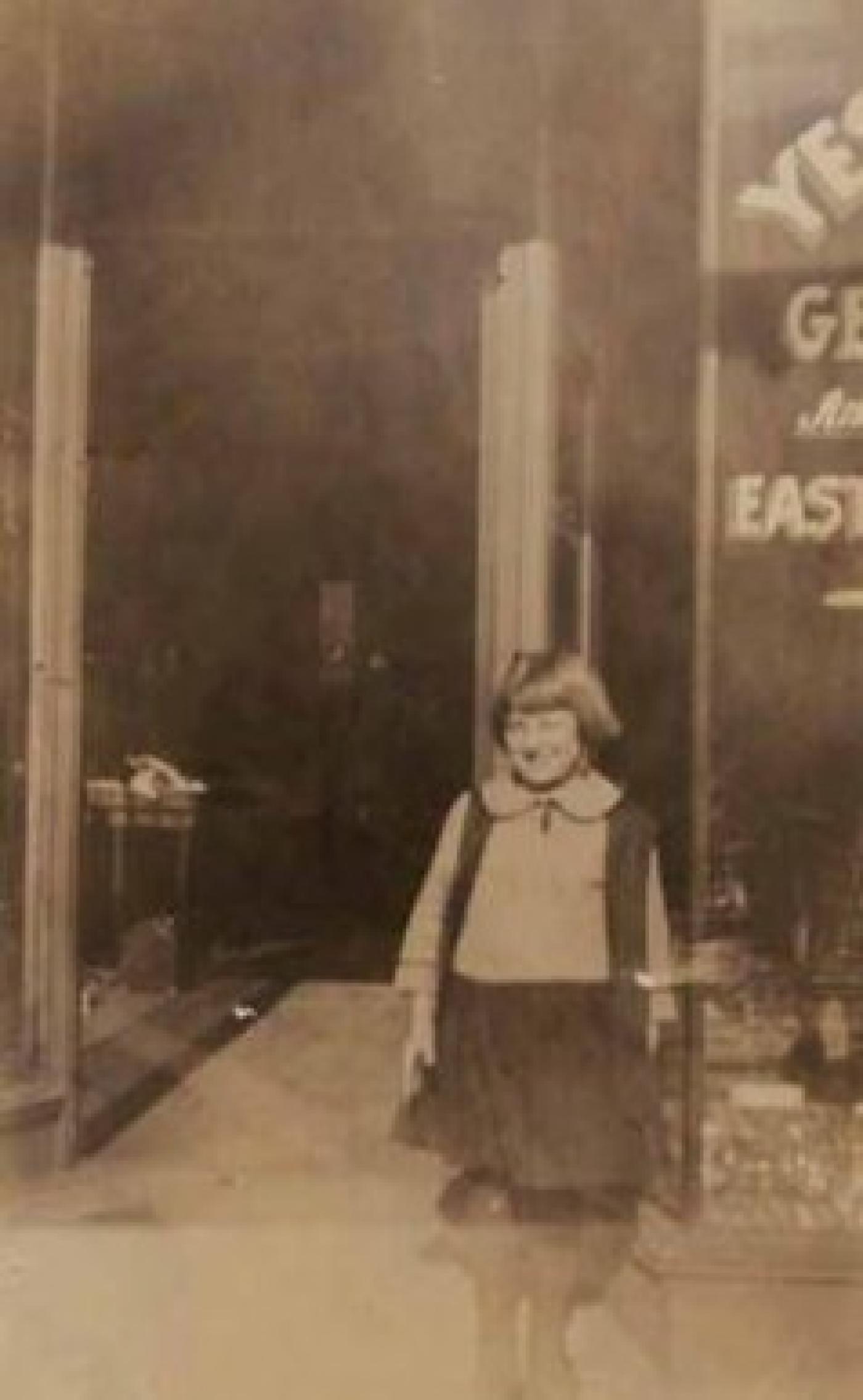 Mildred Kettleman standing outside father's plumbing shop on Yesler Way, Seattle, Washington, 1923   Ralph Kettleman owned a plumbing shop on Yesler Way which he opened ca. 1921. He was the first Jewish plumber in Seattle and the first Jewish member of the Plumbing Union