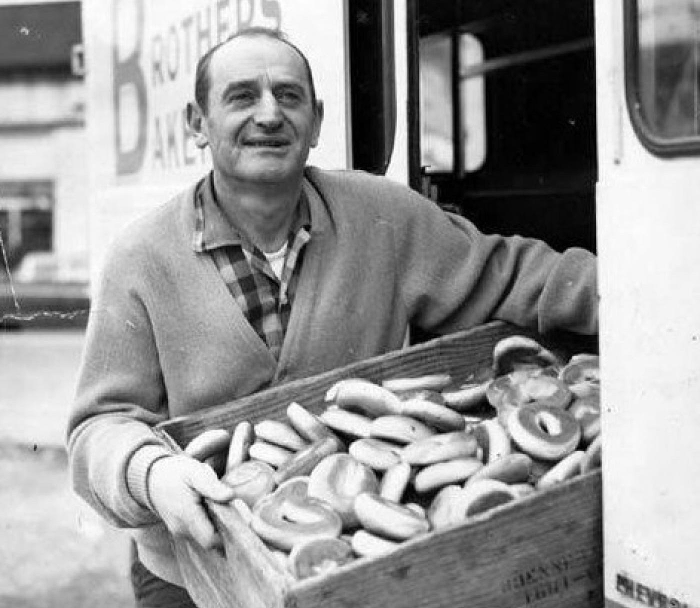 Charlie Brenner holding box of bagels next to Brenner Brothers Bakery delivery truck, Seattle  Courtesy of UW Special Collections