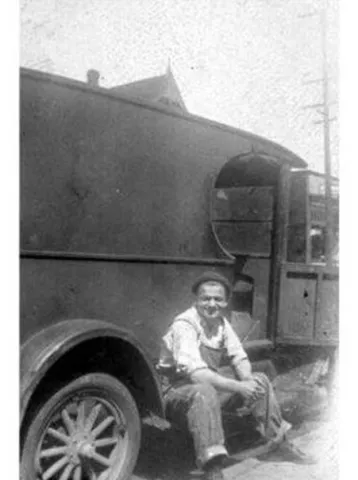 Itsey Brenner sitting on the runner of a Brenner Brothers Bakery delivery truck ca 1920s